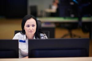 Female operator working in a security data system control room photo