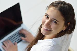relaxed young woman at home working on laptop computer photo