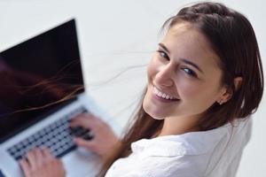 mujer joven relajada en casa trabajando en una computadora portátil foto