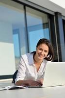 relaxed young woman at home working on laptop computer photo