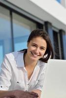 relaxed young woman at home working on laptop computer photo