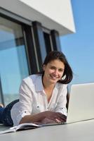 relaxed young woman at home working on laptop computer photo