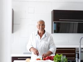 man cooking at home preparing salad in kitchen photo