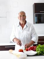 man cooking at home preparing salad in kitchen photo