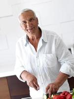 hombre cocinando en casa preparando ensalada en la cocina foto