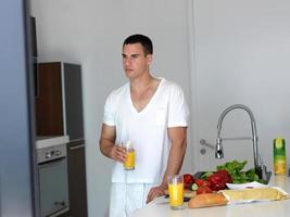 man cooking at home preparing salad in kitchen photo