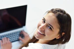 relaxed young woman at home working on laptop computer photo