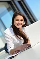 relaxed young woman at home working on laptop computer photo