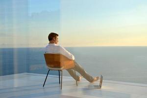 relaxed young man at home on balcony photo