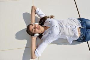 girl listening to the music on white headphones photo