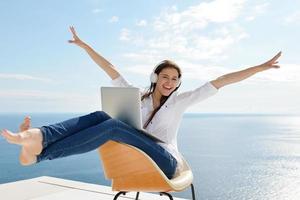 relaxed young woman at home working on laptop photo