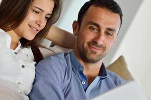 relaxed young couple working on laptop computer at home photo