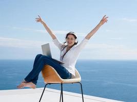 relaxed young woman at home working on laptop photo