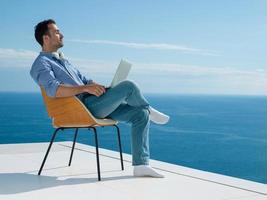 relaxed young man at home on balcony photo