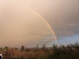 arco iris sobre el campo después de la lluvia foto