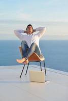 relaxed young man at home on balcony photo