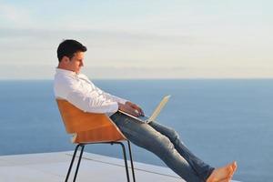 relaxed young man at home on balcony photo