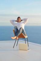 relaxed young man at home on balcony photo