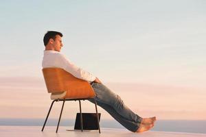 relaxed young man at home on balcony photo