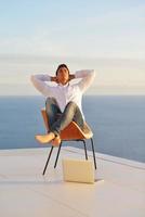 relaxed young man at home on balcony photo