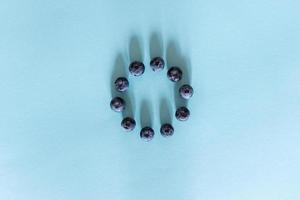 Fresh juicy blueberries on blue background, flat lay with copy space. Blueberries background photo