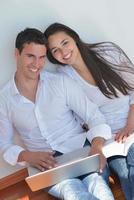 young couple using laptop at home photo