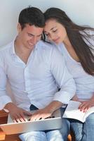 young couple using laptop at home photo