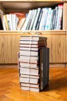 stack of old books tied with rope on parquet floor photo