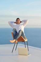 relaxed young man at home on balcony photo