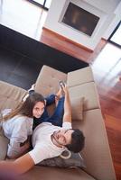 young couple watching tv at home photo