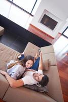 young couple watching tv at home photo