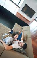 pareja joven viendo tv en casa foto