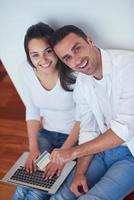 relaxed young couple working on laptop computer at home photo