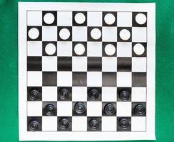 top view of draughts on black and white sheet photo