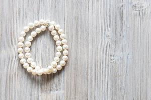 white pearl necklace on gray wood with copyspace photo