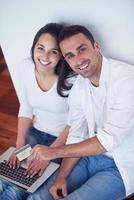 relaxed young couple working on laptop computer at home photo