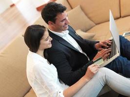 relaxed young couple working on laptop computer at home photo