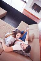 young couple watching tv at home photo