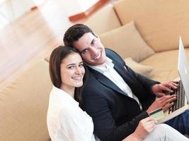 relaxed young couple working on laptop computer at home photo