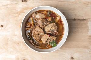 Topview Spicy soup with pork ribs on wood table. photo