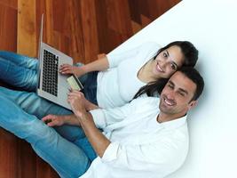 relaxed young couple working on laptop computer at home photo