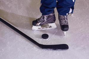 hockey sticsk and puck on ice photo