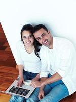 relaxed young couple working on laptop computer at home photo