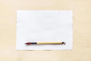 calligraphy brush on blank sheet of white paper photo