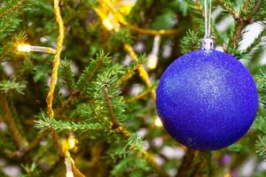 blue ball and light string on twigs of xmas tree photo