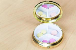 pillbox with mirror with pink and yellow pills photo