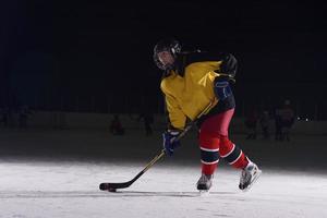 jugador adolescente de hockey sobre hielo en acción foto