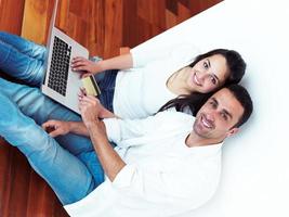 relaxed young couple working on laptop computer at home photo