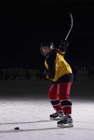 jugador adolescente de hockey sobre hielo en acción foto