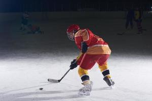 jugador adolescente de hockey sobre hielo en acción foto